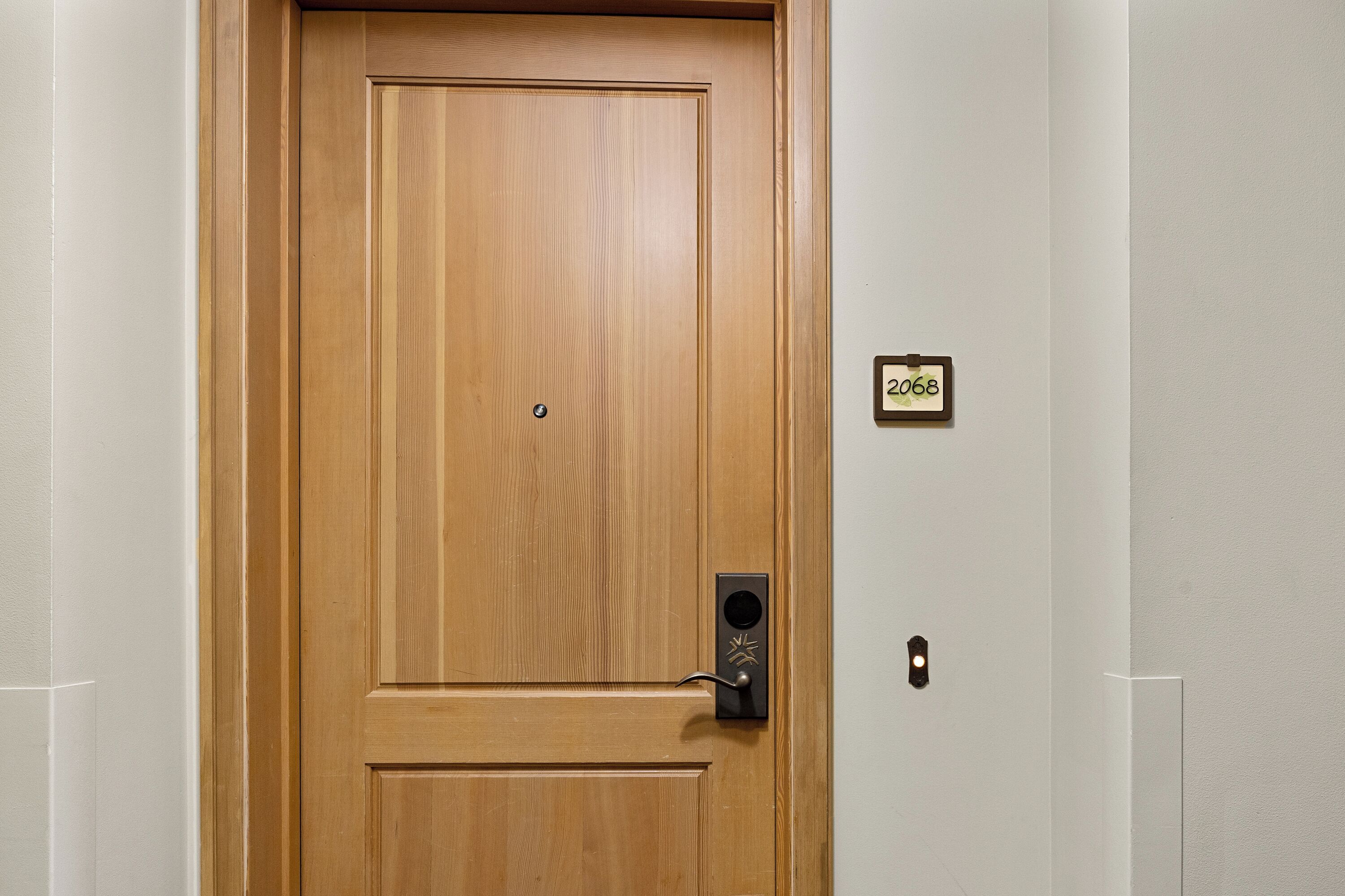 A wooden door with a keyhole and a small sign above it.
