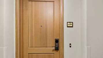 A wooden door with a keyhole and a small sign above it.