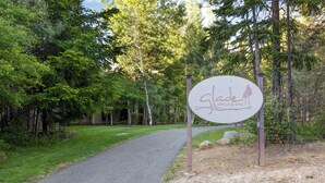 Schild für ein Spa namens 'Glade Spring Spa' in einem bewaldeten Gebiet mit einem gepflasterten Weg.