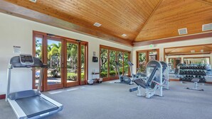 A gym with treadmills, weight machines, and dumbbells.