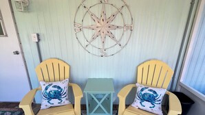 A room with two yellow chairs, a small table, and a nautical-themed wall decoration. - Absolutely Darling private little oasis !  (Holly Ridge)