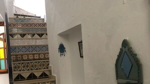 A staircase with a variety of patterned tiles leading to a landing. - Atelier D (Tunis)