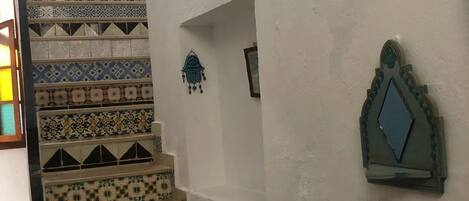 A staircase with a variety of patterned tiles leading to a landing.