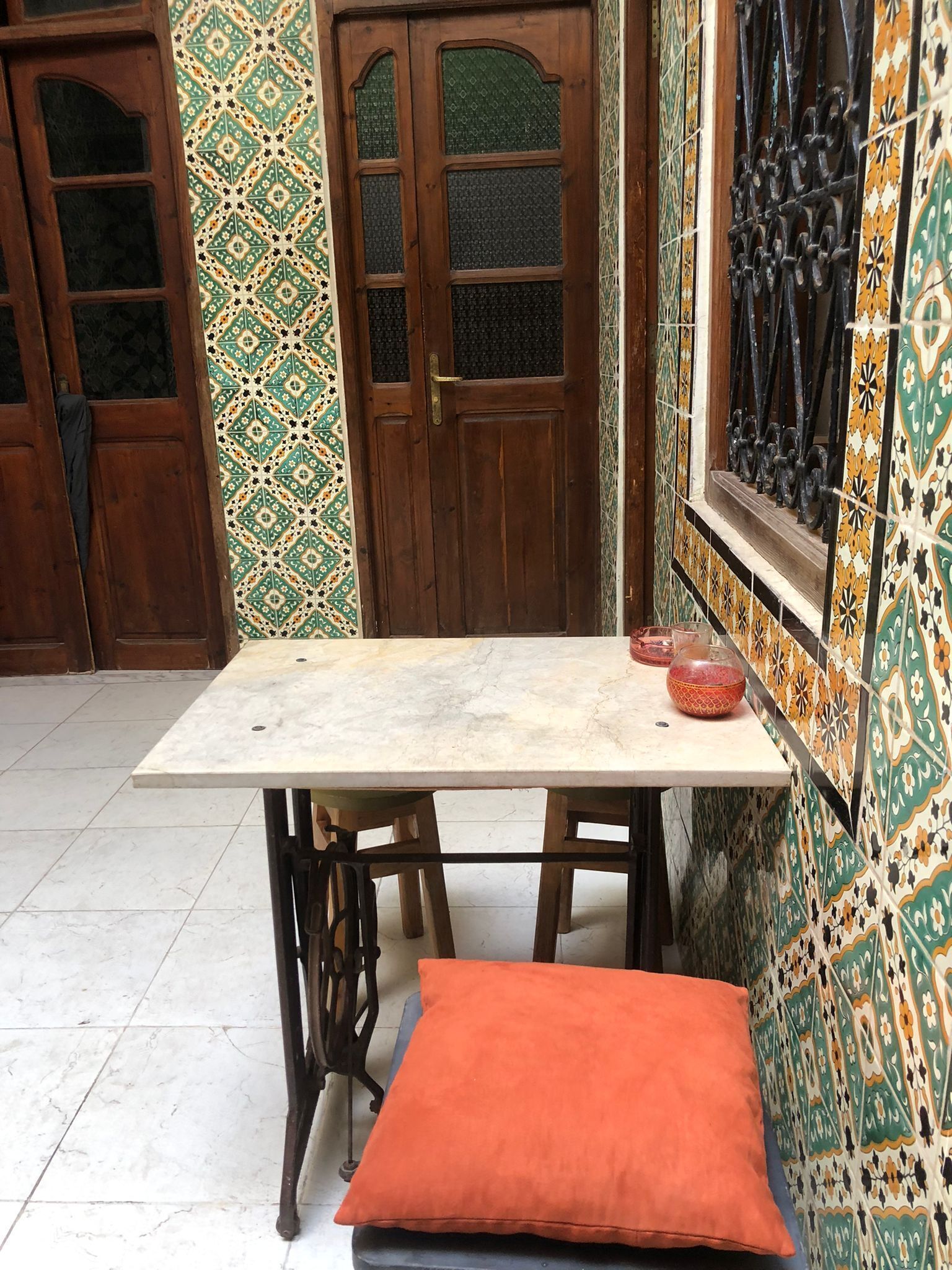 A room with a wooden door, a marble table, and patterned walls.