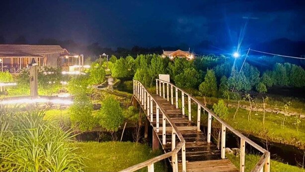A wooden staircase leading to a building with a light source at the top. - Sinbad Beach Resort (Saint Martin's Island)