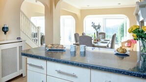 A spacious kitchen with a marble countertop, white cabinetry, and a view of the outdoors. - 3 bedroom accommodation in Bishops Tawton, near Barnstaple (Bishops Tawton, near Barnstaple)