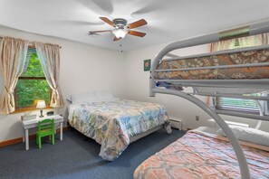 A bunk bed room with a desk, chair, and a ceiling fan. - Charming 3-bedroom house with AC and WiFi on Sandy Pond. (Sandy Creek)