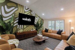 A living room with a television, two sofas, a coffee table, and a patterned rug.