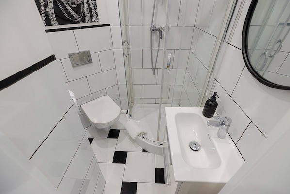 A modern bathroom with a toilet, bidet, and sink. - MG Pokoje w Warszawie by Metro Rondo ONZ (Warsaw)