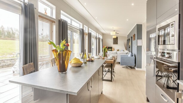 A modern kitchen with a dining area, large windows, and a view of the outdoors. - 2 bedroom accommodation in Roadford Lake, near Launceston (Roadford Lake, near Launceston)