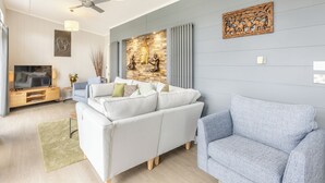 A modern living room with a sofa, a television, and a ceiling fan. - 2 bedroom accommodation in Roadford Lake, near Launceston (Roadford Lake, near Launceston)