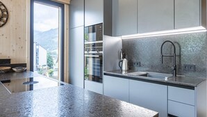 A modern kitchen with a granite countertop, stainless steel appliances, and a view of the outdoors. - Amazing Penthouse With Sauna (Sankt Georgen am Kreischberg)