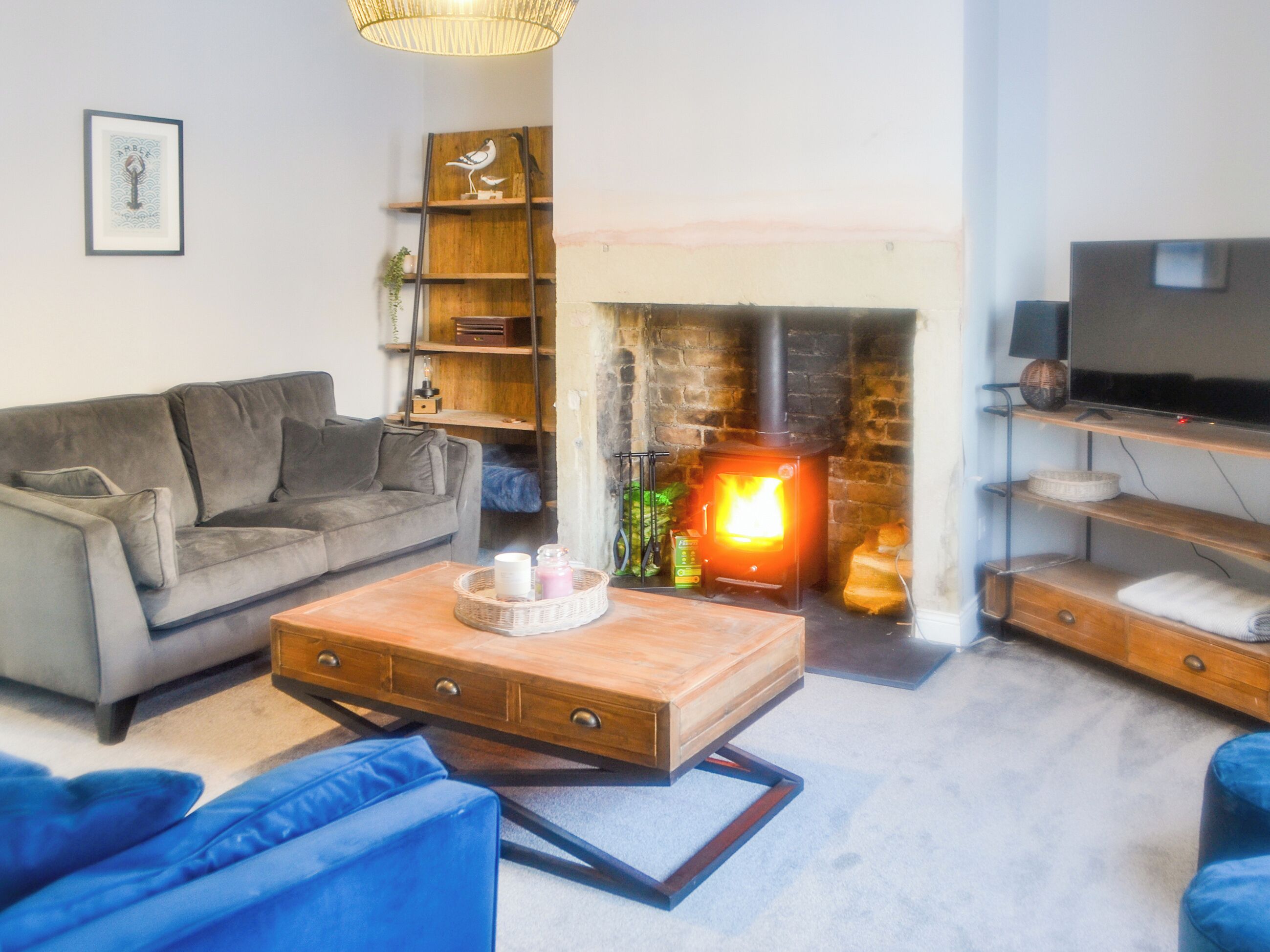 Un salon chaleureux avec une cheminée, un canapé, une table basse et un meuble pour la télévision.