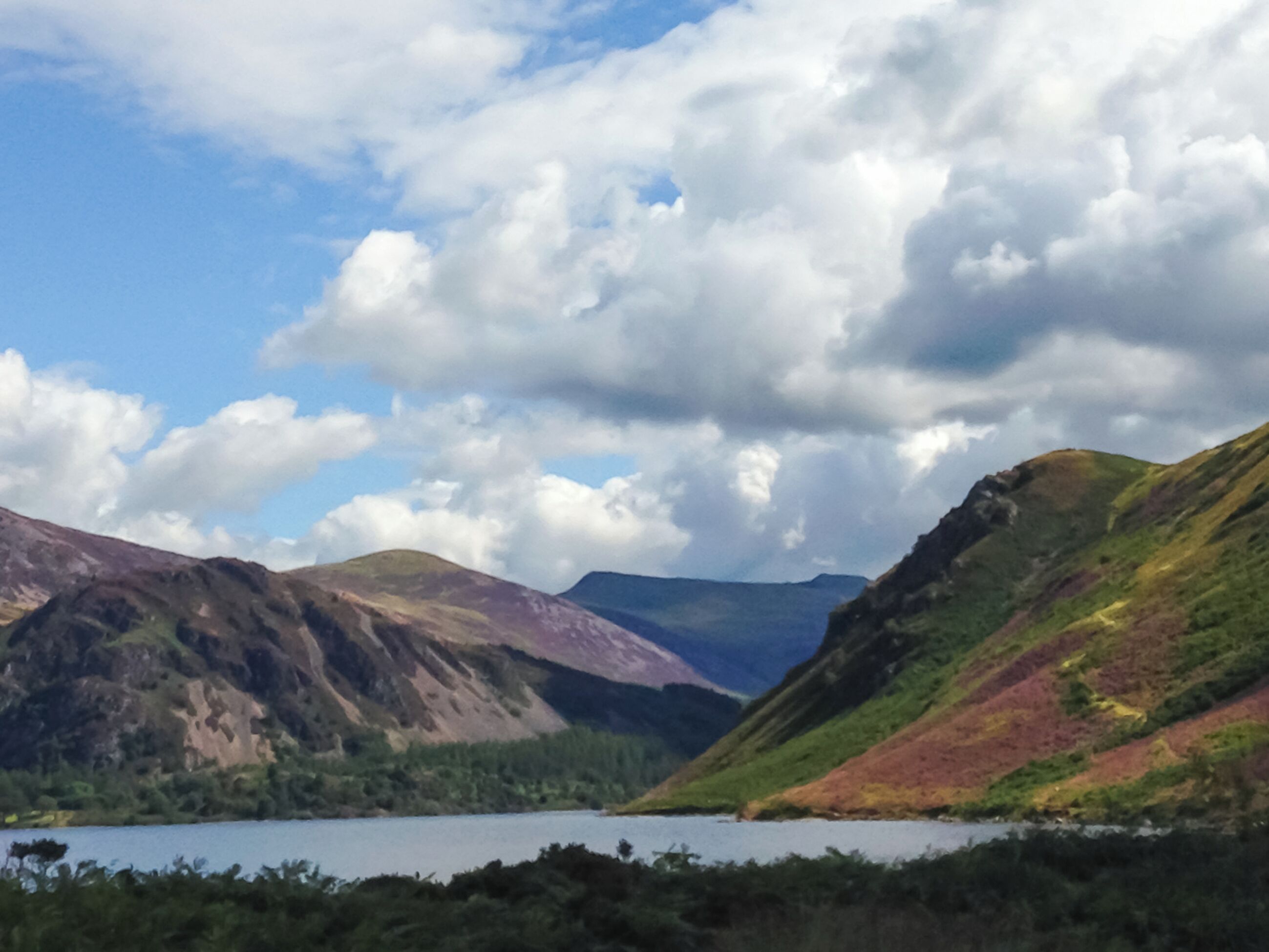 A mountainous landscape with a lake and hills.