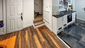 Une cuisine moderne avec un plan de travail noir, des armoires blanches et une cuisinière intégrée.