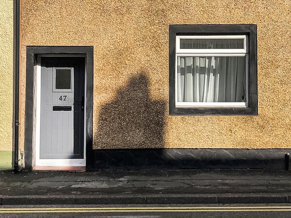 A building with a door marked '47' and a window with a curtain.