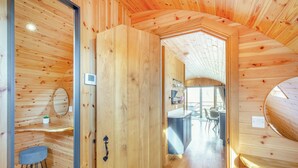 Un intérieur en bois comprenant un coin cuisine, une table à manger et un petit espace salon.