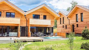 A modern wooden cabin with a swimming pool, outdoor seating, and a covered patio. - Attractive Holiday Home With Pool (Sankt Georgen am Kreischberg)