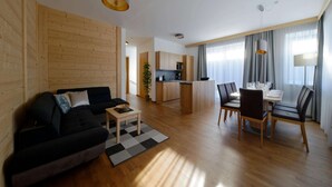 Un salon moderne comprenant un canapé, une table basse et un coin repas avec des chaises et une table.
