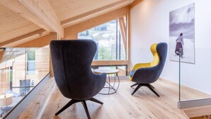 A modern interior with high ceilings, wooden beams, and large windows offering views of the outside. - Lovely Penthouse With Sauna (Sankt Georgen am Kreischberg)