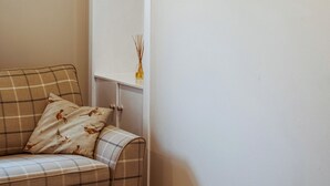 A plaid sofa with a decorative pillow against a white wall. - 2 bedroom accommodation in Methven, near Perth (Methven, near Perth)