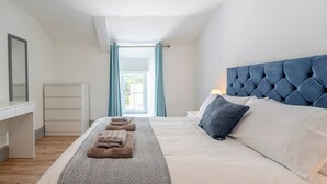 A bedroom with a bed, bedside table, and a window with curtains. - 5 bedroom accommodation in Eglwyswrw (Eglwyswrw)