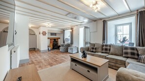 A spacious living room with a fireplace, a sofa set, and a wooden coffee table. - 5 bedroom accommodation in Eglwyswrw (Eglwyswrw)