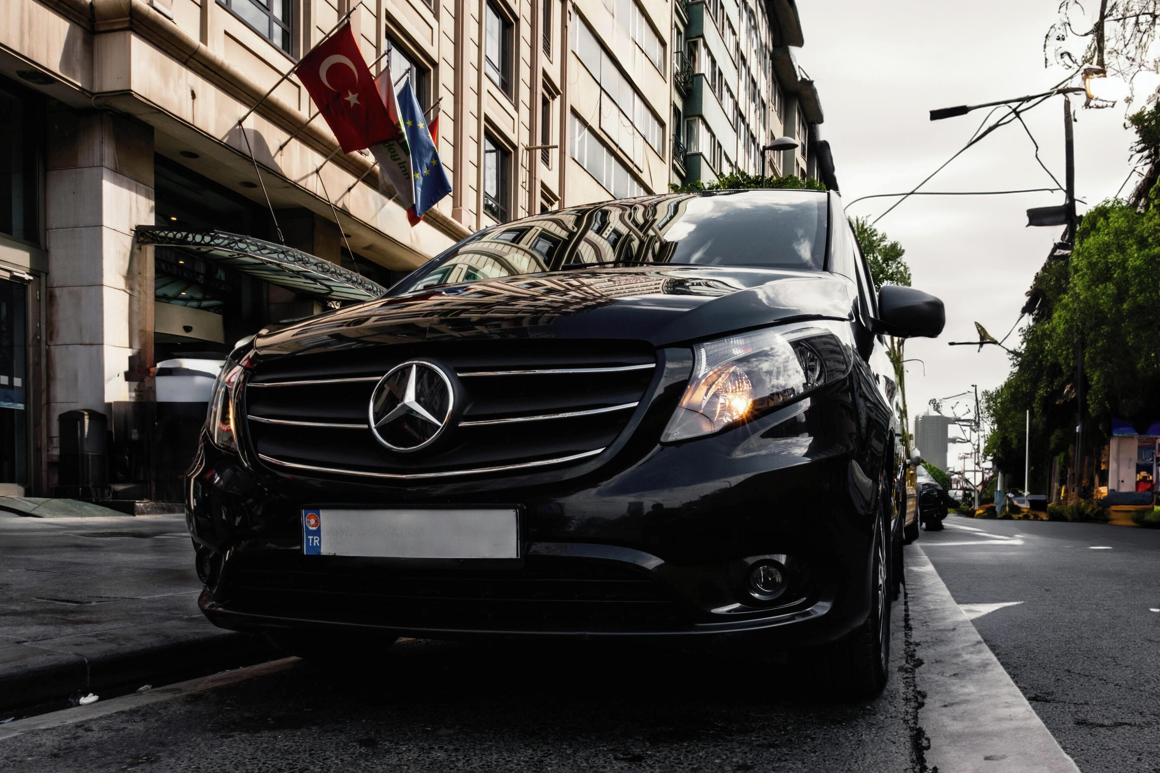 Un Mercedes-Benz negro estacionado en una calle de la ciudad.
