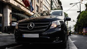 Un Mercedes-Benz negro estacionado en una calle de la ciudad.