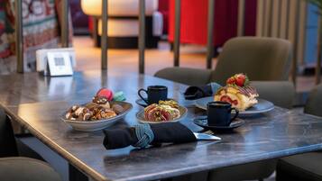 Una mesa con diversos postres, una taza y una servilleta.