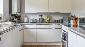 Eine moderne Küche mit weißen Schränken, einem Edelstahltoaster und einem Wasserkocher.