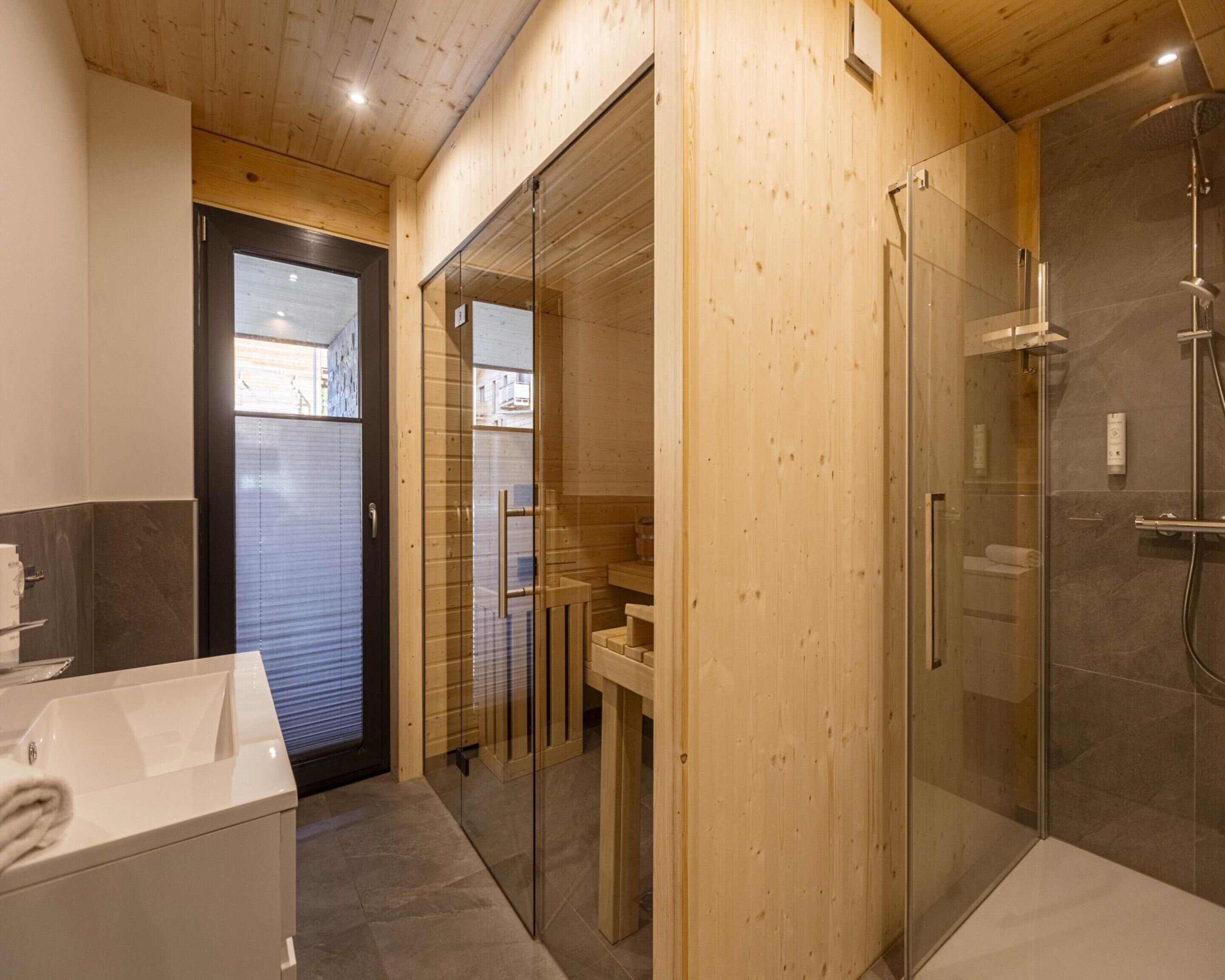 Um banheiro moderno com decoração em madeira, box de vidro e vaso sanitário à vista.