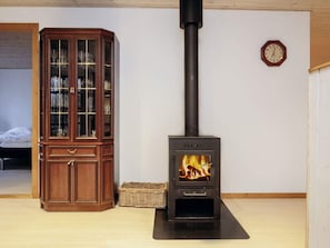 A room with a wooden cabinet and a wood-burning stove. - 6 Person Holiday Home in Laeso (Læsø)
