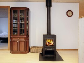 Quarto com um armário de madeira e uma lareira a lenha.