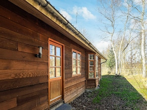 A wooden cabin with a front door, two windows, and a small porch area. - 6 Person Holiday Home in Laeso (Læsø)