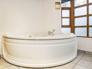 A large, freestanding bathtub in a bathroom with a window. - 6 Person Holiday Home in Laeso (Læsø)