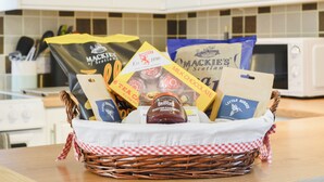 Une cuisine avec un panier en osier contenant divers aliments et des sachets de collations.