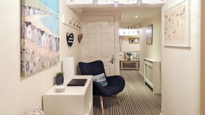A hallway with striped carpet, a desk with a laptop, a chair, and a small table with a plant. - The Snug, Lynmouth - UK41696 (Lynmouth)