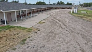A motel with a covered parking area and a sign indicating it is the West Lake Inn.