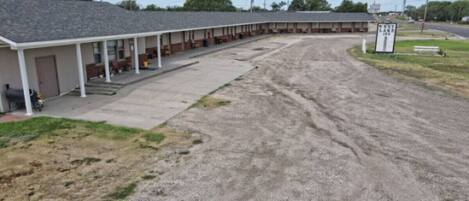 Un motel con zona de estacionamiento techada y un cartel que indica 'West Lake Inn'.