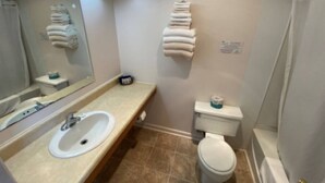 Une salle de bain équipée d’un lavabo, de toilettes et d’un porte-serviettes.