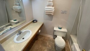 A bathroom with a sink, toilet, and towel rack. - Room 114 - Double Full - Sleeps 4 - West Lake Grandvue Inn (Downs)
