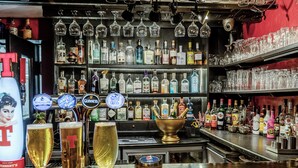 Eine Bar mit einer Auswahl an Spirituosen, Gläsern und einer Theke.