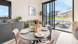 Cocina moderna con comedor, puertas correderas de vidrio a un patio y vistas de una zona residencial.