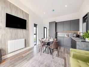 A modern kitchen with dark cabinets, a built-in oven, and a sink.