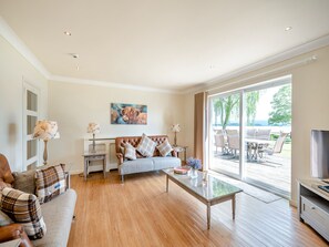 Ein geräumiges Wohnzimmer mit Sofa, Couchtisch und einem Gemälde von einem Stier.