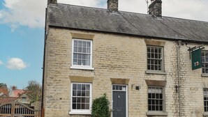A stone building with a traditional design, featuring a central door and two windows on the ground floor. - 2 bedroom accommodation in Hovingham, near Helmsley (Hovingham, near Helmsley)