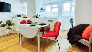 Un espacio habitable compacto con comedor, cocina y zona de estar.