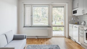 Une cuisine moderne avec des meubles blancs, un four à micro-ondes et une bouilloire.