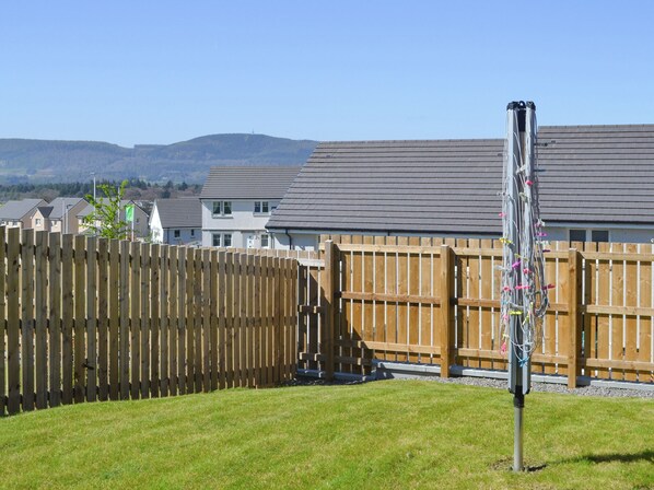 A residential area with houses, a wooden fence, and a grassy yard.